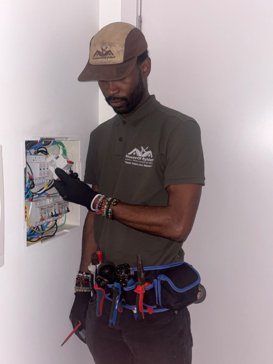 Profissional uniformizado da House of Syldor trabalhando em quadro elétrico